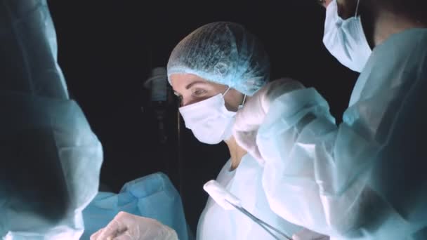 Старший хірург в операційній кімнаті, де пацієнт чекає на нього, і він починає операцію. Справжня сучасна лікарня з автентичним обладнанням. — стокове відео