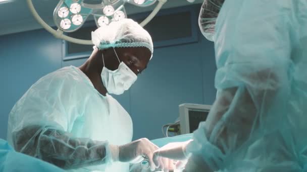 The senior surgeon in the operating room, where the patient is waiting for him, and he begins the operation. Real Modern Hospital with Authentic Equipment. — Stock Video