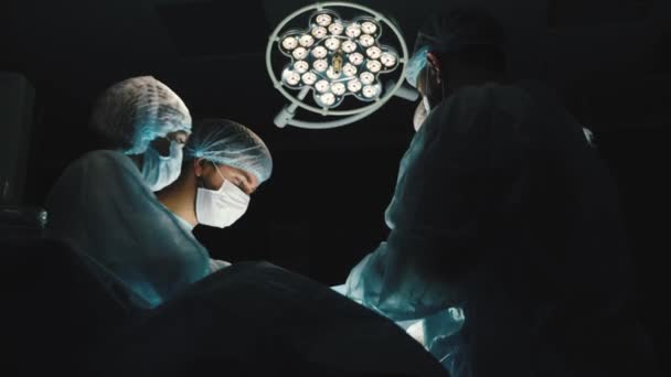 The senior surgeon in the operating room, where the patient is waiting for him, and he begins the operation. Real Modern Hospital with Authentic Equipment. — Stock Video