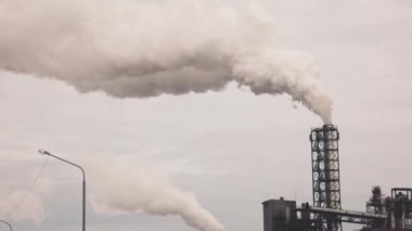 Boru kalınlığında beyaz dumanı olan sanayi bölgesi güneşin aksine fabrika borusundan dökülüyor. Çevrenin kirliliği: dumanlı bir pipo. Hava görünümü