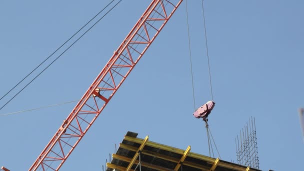 Construction cranes move building materials and work on the construction of multi-storey residential buildings — Stock Video