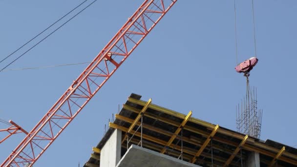 Baukräne bewegen Baumaterialien und arbeiten am Bau mehrstöckiger Wohnhäuser — Stockvideo