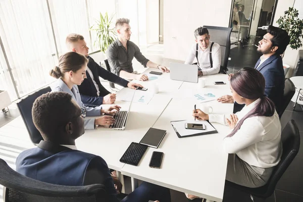 Un equipo de jóvenes empresarios que trabajan y se comunican en una oficina. Corporativossteam y gerente en una reunión — Foto de Stock