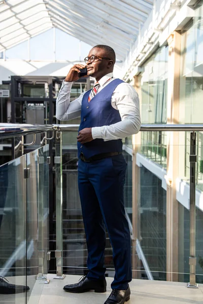 Retrato de un hombre de negocios en traje están de pie en el fondo de las oficinas de vidrio. — Foto de Stock