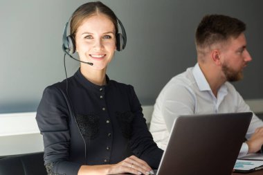 Kadın müşteri hizmetleri çalışanı portresi, çağrı merkezi gülümseyen operatör ve ofis telefonu.