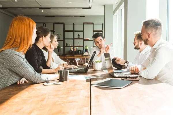 Un equipo de jóvenes empresarios que trabajan y se comunican en una oficina. Corporativossteam y gerente en una reunión. — Foto de Stock
