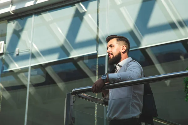 Retrato de un hombre de negocios en traje están de pie en el fondo de las oficinas de vidrio. — Foto de Stock