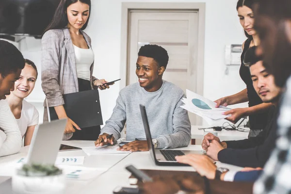 Un equipo de jóvenes trabajadores de oficina, empresarios con portátil trabajando en la mesa, comunicándose juntos en una oficina. Corporativosvapor y gerente en una reunión. coworking. — Foto de Stock