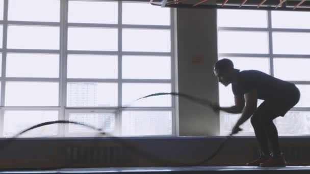 Svalnatý muž cvičí v tělocvičně. Koncept CrossFit. tělocvična, sportovkyně, lano, trénink, sportovkyně, tělocvična — Stock video