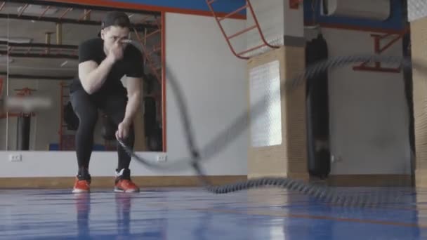 Μυώδης άνθρωπος που γυμνάζεται στο γυμναστήριο κάνοντας ασκήσεις. Σχέδιο CrossFit. γυμναστήριο, αθλητισμός, σχοινί, προπόνηση, αθλητής, προπόνηση, ασκήσεις έννοια — Αρχείο Βίντεο