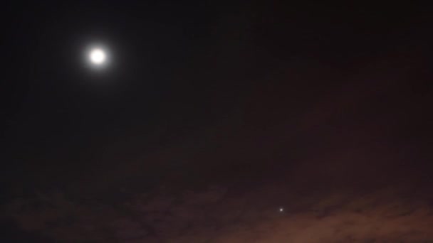 Vidéo de nuit Timelapse. La lune et les étoiles se déplacent à travers le ciel parmi les nuages 
