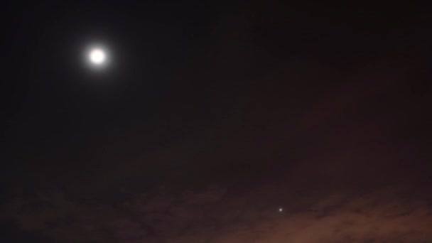 Timelapse night video. The moon and stars moves across the sky among the clouds — Stock Video