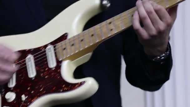 De gitarist is lid van het muzikale collectief. Close-up van een gitaarspel. dynamische omgeving — Stockvideo