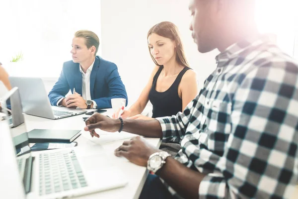 Un equipo de jóvenes trabajadores de oficina, empresarios con portátil trabajando en la mesa, comunicándose juntos en una oficina. Corporativosvapor y gerente en una reunión. coworking. — Foto de Stock