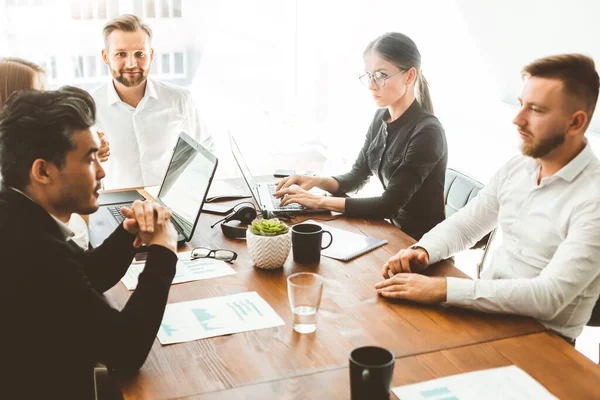 Un equipo de jóvenes empresarios que trabajan y se comunican en una oficina. Corporativossteam y gerente en una reunión. — Foto de Stock