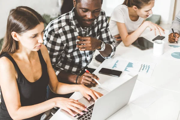 Un equipo de jóvenes trabajadores de oficina, empresarios con portátil trabajando en la mesa, comunicándose juntos en una oficina. Corporativosvapor y gerente en una reunión. coworking. — Foto de Stock