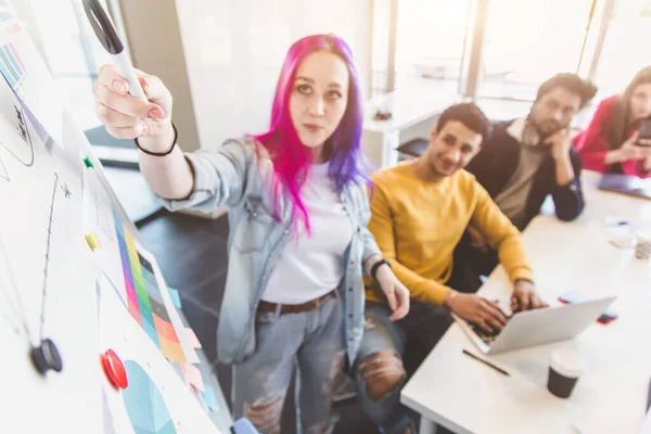 Grupo de ejecutivos multiétnicos discutiendo durante una reunión. Hombre y mujer de negocios sentados alrededor de la mesa en la oficina y sonriendo. Un equipo de jóvenes diseñadores creativos — Foto de Stock