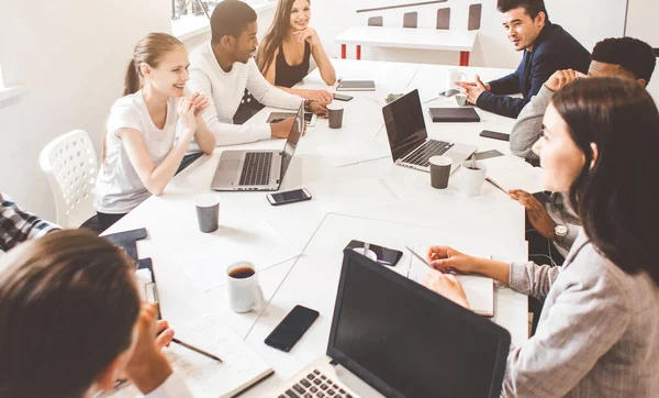 Un equipo de jóvenes trabajadores de oficina, empresarios con portátil trabajando en la mesa, comunicándose juntos en una oficina. Corporativosvapor y gerente en una reunión. coworking. — Foto de Stock