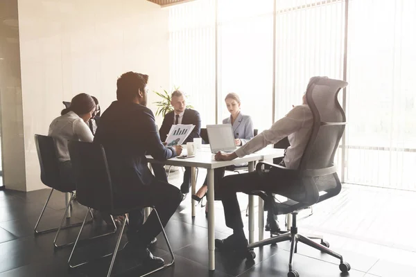 Siluetas de gente sentada a la mesa. Un equipo de jóvenes empresarios que trabajan y se comunican en una oficina. Corporativossteam y gerente en una reunión — Foto de Stock