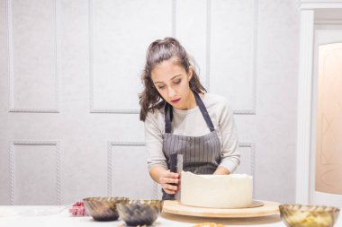 Şekerleme spatulası ile bisküvi pastası üzerine beyaz krema. Ev yapımı hamur işi, kek pişirme....