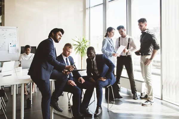 Un equipo de jóvenes empresarios que trabajan y se comunican en una oficina. Corporativossteam y gerente en una reunión. — Foto de Stock