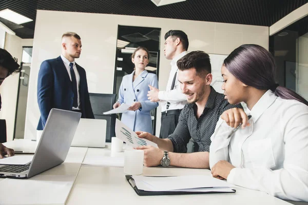 Un equipo de jóvenes empresarios que trabajan y se comunican en una oficina. Corporativossteam y gerente en una reunión. — Foto de Stock