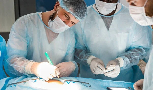 Le chirurgien principal dans la salle d'opération, où le patient l'attend, et il commence l'opération. Véritable hôpital moderne avec équipement authentique. — Photo