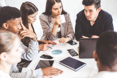 Genç ofis çalışanlarından oluşan bir ekip, masada çalışan iş adamları, ofiste birlikte iletişim kuruyorlar. Şirket buharı ve bir toplantıda yönetici. eşçalışma.