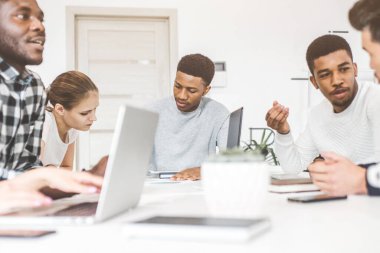 Genç ofis çalışanlarından oluşan bir ekip, masada çalışan iş adamları, ofiste birlikte iletişim kuruyorlar. Şirket buharı ve bir toplantıda yönetici. eşçalışma.
