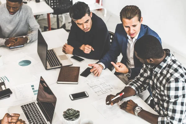 Un equipo de jóvenes trabajadores de oficina, empresarios con portátil trabajando en la mesa, comunicándose juntos en una oficina. Corporativosvapor y gerente en una reunión. coworking. — Foto de Stock