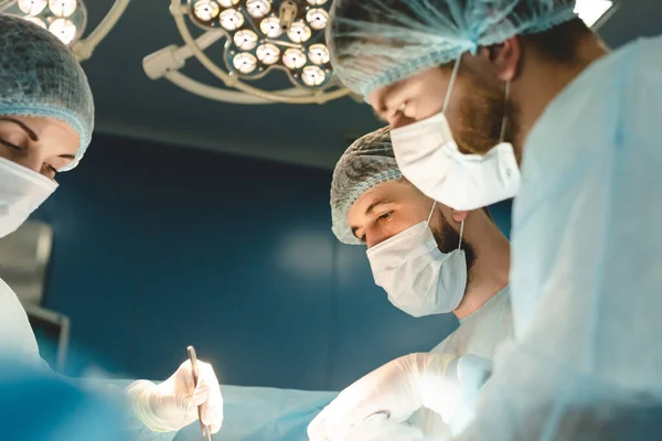 El cirujano sénior en el quirófano, donde el paciente lo está esperando, y comienza la operación. Hospital Real Moderno con Equipo Auténtico. —  Fotos de Stock