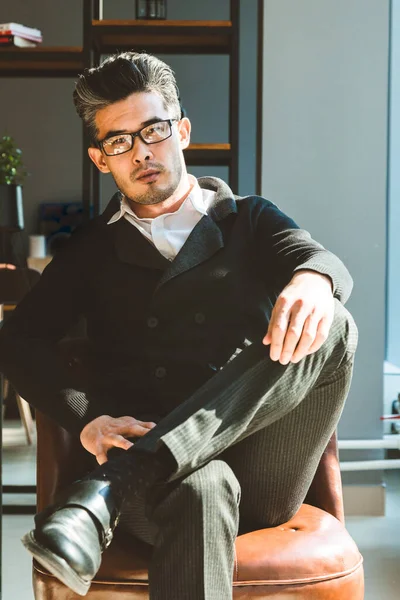 Retrato de un joven hombre de negocios sentado en la silla en el interior . — Foto de Stock