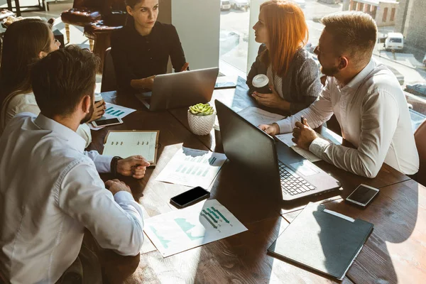 Un equipo de jóvenes empresarios que trabajan y se comunican en una oficina. Corporativossteam y gerente en una reunión. — Foto de Stock