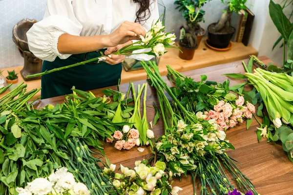 आकर्षक युवा महिला फूलों की दुकान में काम कर रही है . — स्टॉक फ़ोटो, इमेज