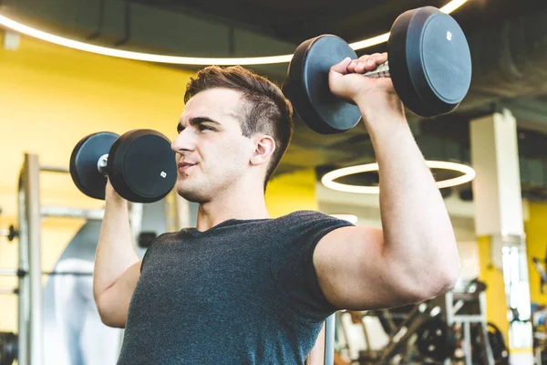 Edzés súlyzóval a tornateremben.Fitness férfiak gyakorló emelés súlyzók. Fitness izmos test. Edzés az edzőteremben. — Stock Fotó