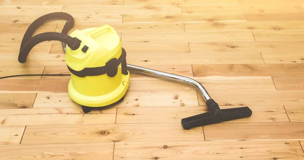 professinal cleaning. yellow vacuum cleaner on wooden floor