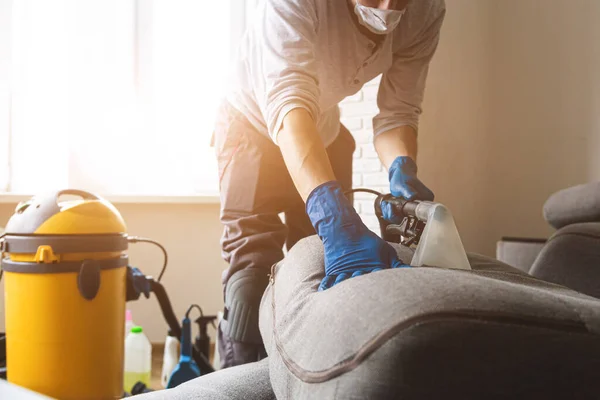 Homem limpeza do sofá limpeza química com método de extração profissional. Mobília estofada. Limpeza antecipada da primavera ou limpeza regular. — Fotografia de Stock