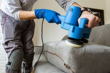 Kuru temizlemeci adam, plastik eldiven temizleme koltuğunu profesyonel yöntemle teslim etti. Bahar başında düzenli temizlik. Ticari temizlik şirketi konsepti.