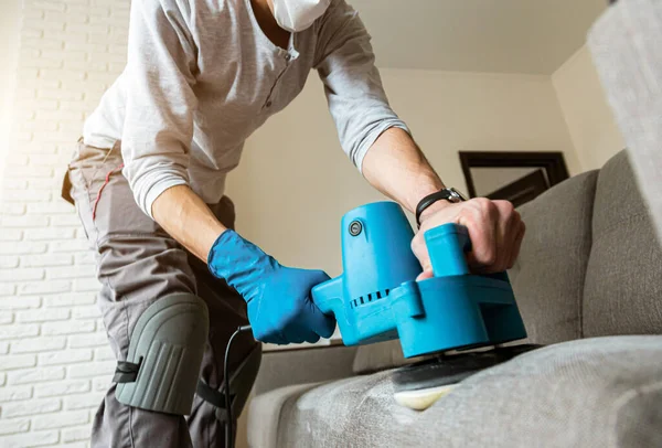 Man handen close-up in beschermende rubberen handschoen, Stomerij werknemer het verwijderen van vuil uit meubels in flat, close-up, stofzuigen sofa met professionele apparatuur. — Stockfoto