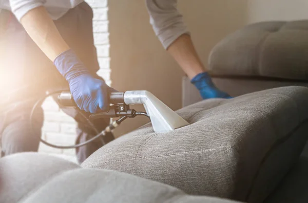 Man kemtvätt anställd hand i skyddande gummihandske rengöring soffa med professionellt extraktion metod. Tidig vårstädning. Kommersiell städfirma — Stockfoto