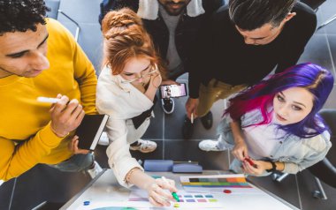 Çok ırklı yöneticilerden oluşan bir grup toplantıda tartışıyorlar. İş adamı ve kadın ofiste oturmuş gülümsüyorlar. Genç yaratıcı tasarımcılardan oluşan bir takım.