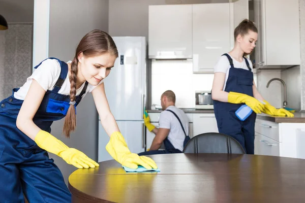 Cleaning service with professional equipment during work. professional kitchenette cleaning, sofa dry cleaning, window and floor washing. man and women in uniform, overalls and rubber gloves — Stock Photo, Image