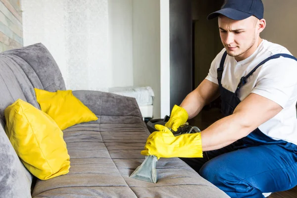 Cleaning service with professional equipment during work. professional kitchenette cleaning, sofa dry cleaning, window and floor washing. man and women in uniform, overalls and rubber gloves