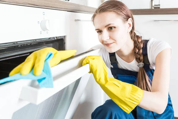 Serviço de limpeza com equipamento profissional durante o trabalho. limpeza kitchenette profissional, sofá limpeza a seco, janela e lavagem de piso. homem e mulher de uniforme, macacão e luvas de borracha — Fotografia de Stock