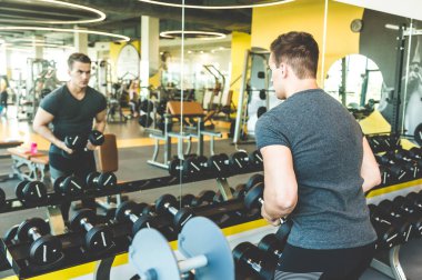 Spor salonunda halter ağırlıklarıyla çalışıyorum. Spor yapan erkekler halterleri kaldırıyor. Fitness kaslı vücut. Spor salonunda egzersiz..