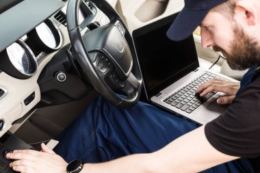 Araba tamiri servisinde çalışan profesyonel bir tamirci. Bilgisayar video araştırması. Motor kontrolleri. Servis İstasyonu.