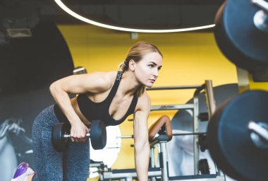Spor salonunda halter ağırlıklarıyla çalışıyor. Spor yapan kadınlar halterleri kaldırıyor. Fitness kaslı vücut. Spor salonunda egzersiz..