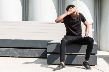 Atletik genç Afroamerikalı adam gezinti güvertesinde koşuyor. Siyah erkek koşucu dışarıda koşuyor. Sağlıklı yaşam tarzı kavramı.