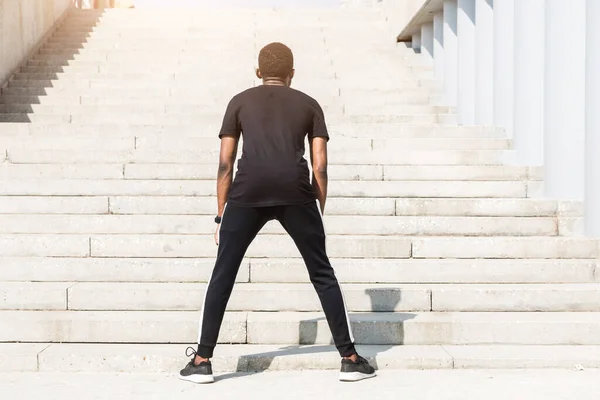 Atlético joven afroamericano corriendo en el paseo marítimo. Corredor masculino negro corriendo al aire libre. concepto de estilo de vida saludable . —  Fotos de Stock