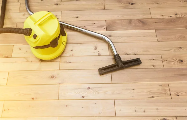 Pembersihan professinal. Kuning vacuum cleaner di lantai kayu — Stok Foto